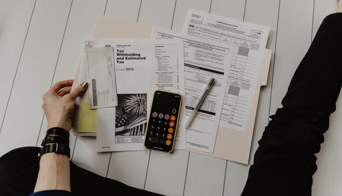 Persona planificando el ahorro familiar con calculadora y documentos